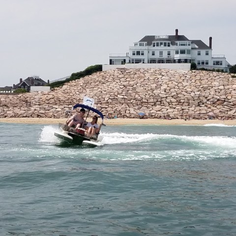 Boater on river in front of river house