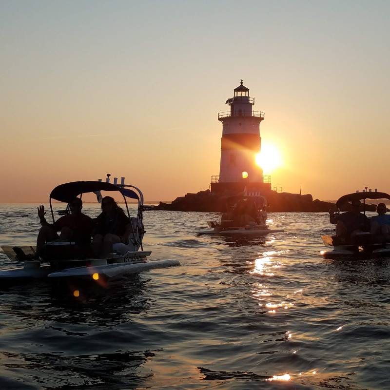 Sunset over the Mystic River with boats and lighthouse