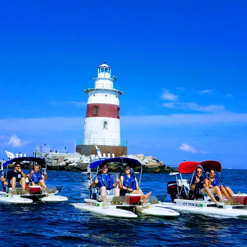 Three boats in front of lighthouse