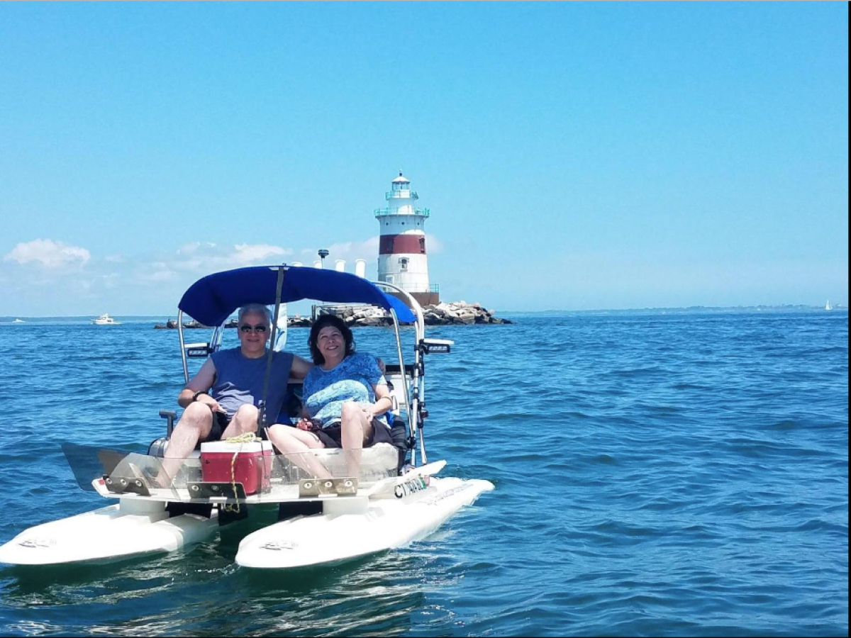 a man riding on the back of a boat in a bod y of water