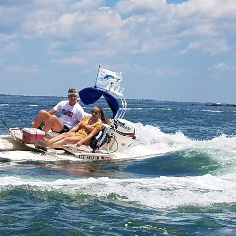 two people riding a CraigCat boat in Fishers Island Sound