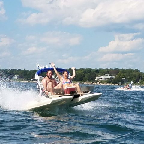 a man riding on the back of a boat in the water